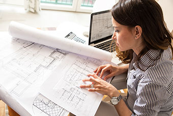 Female architect inspecting plans