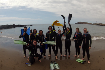 A group of students in snorkelling gear on a beach