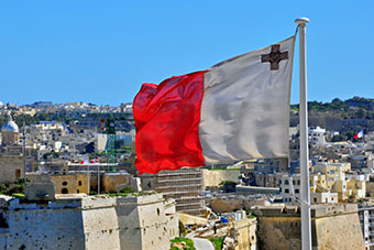 Maltese flag and Maltese landscape in background