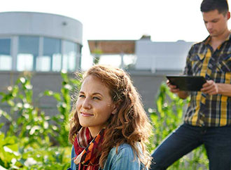 Two people, building in the background amidst greenery