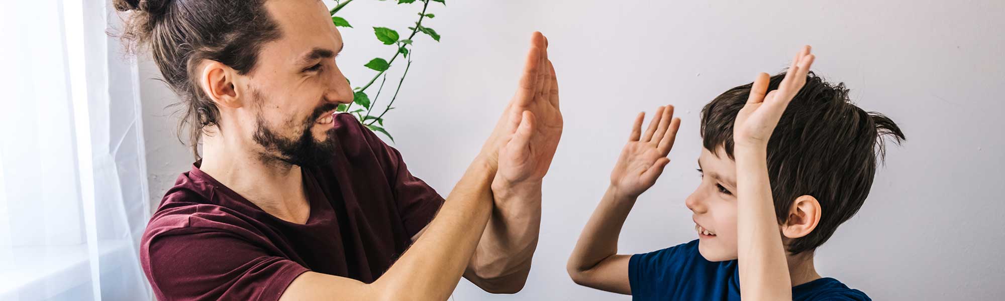 Happy autism boy during therapy with school tutor, learning and having fun together