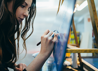 Close up portrait of beautiful and authentic young female artist or painter create art piece.
