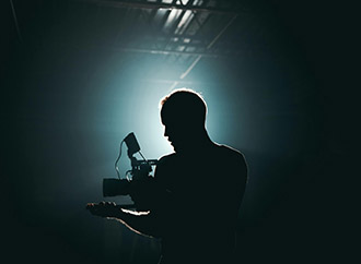 A man with a camera on a dark background
