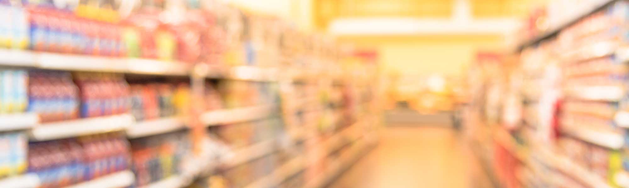 Blurred image of supermarket aisle and shelves.