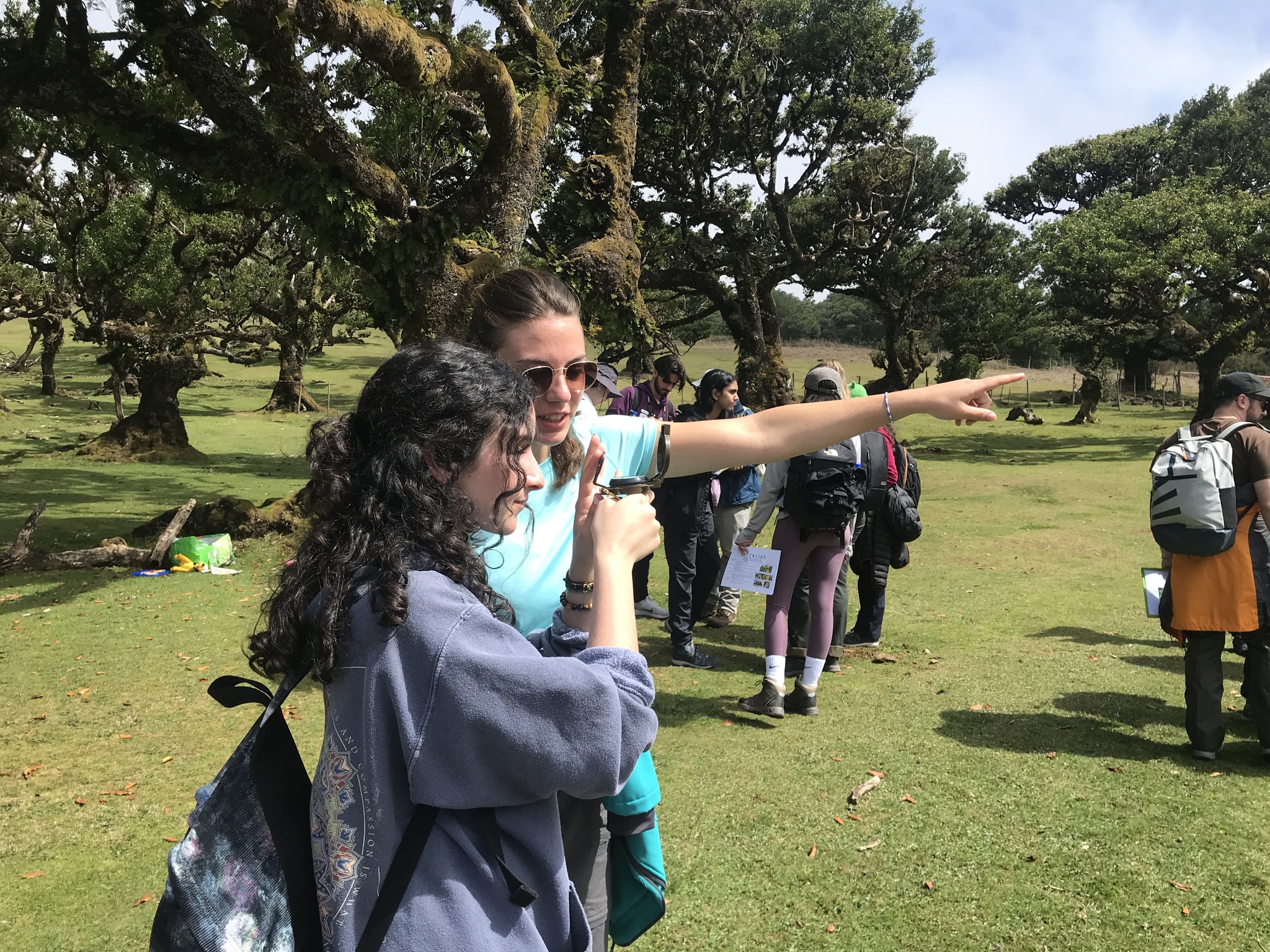 Students determining wind direction using compass bearings as part of an exercise measuring the microclimate of the Laurissilva forest.