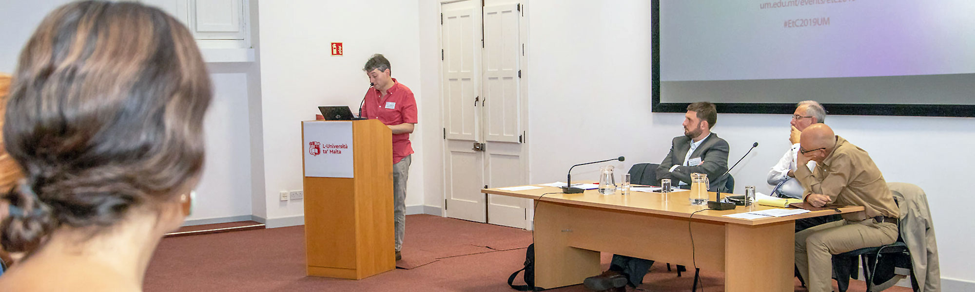 Conference session in progress - speakers and audience