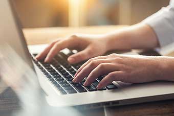 Woman typing at a computer