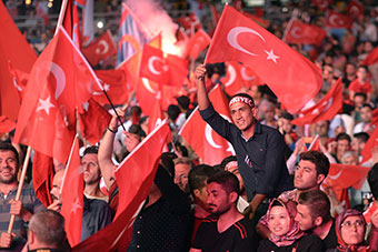People wave turkish flags during rally