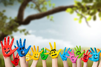 Children's hands painted colourful and a country background