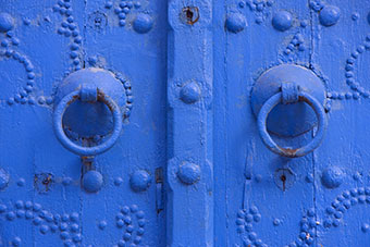A blue door with two door knobs