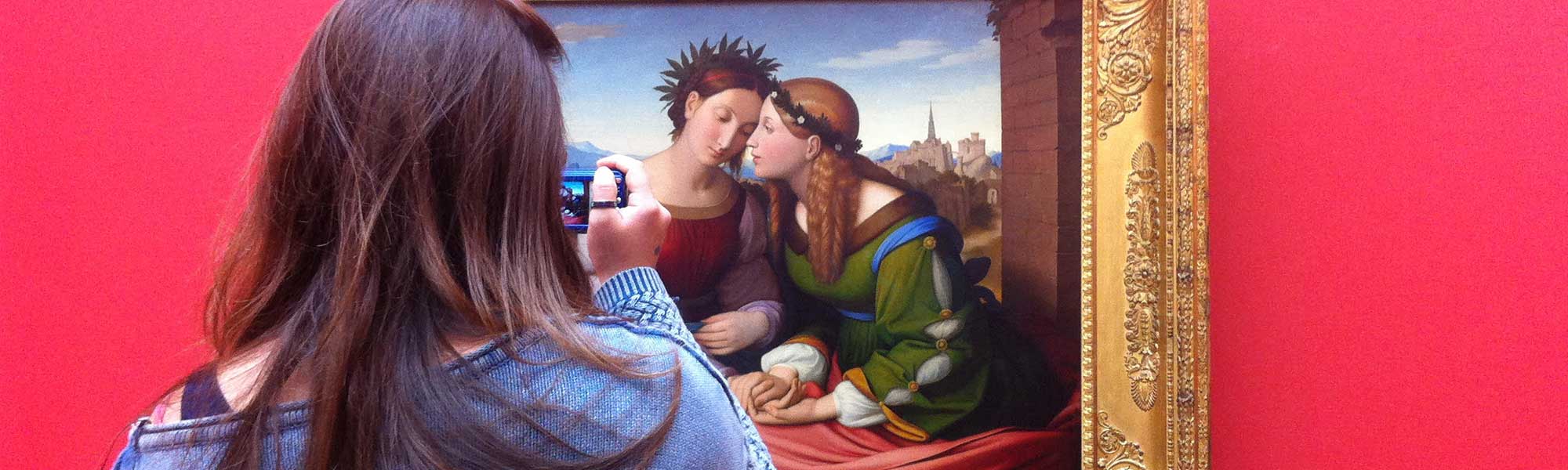 A student taking a photo of a painting