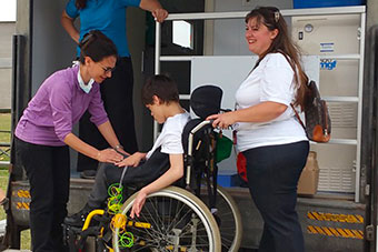 Dental Staff helping a wheelchair user access the UM mobile dental clinic