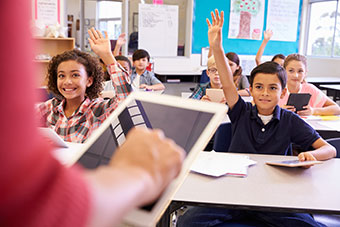 Children raising their hands during a classroom session