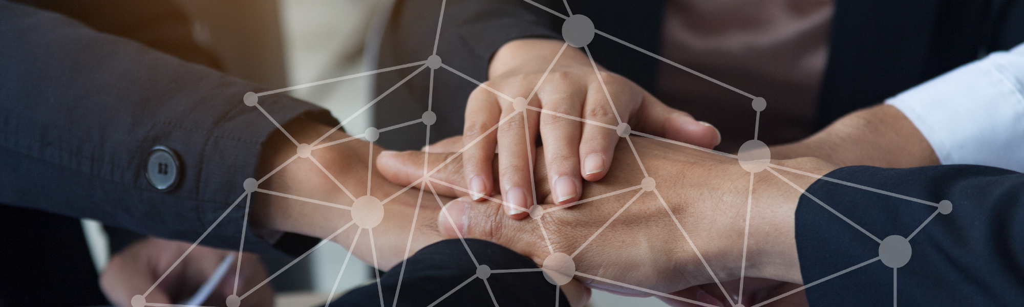 A number of people placing their hands on top of each other