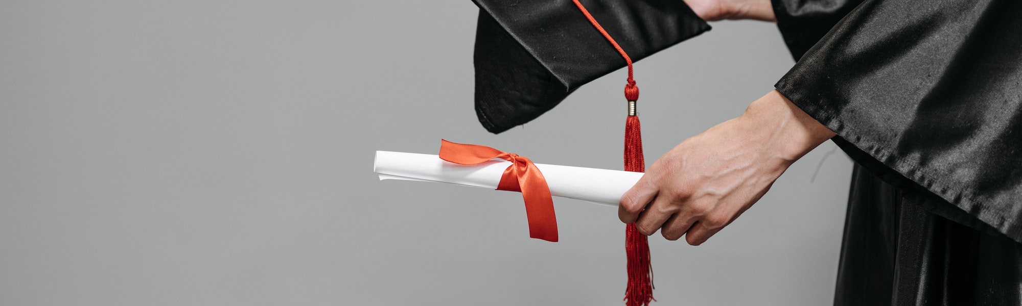 A number of students throwing graduation hats into the air