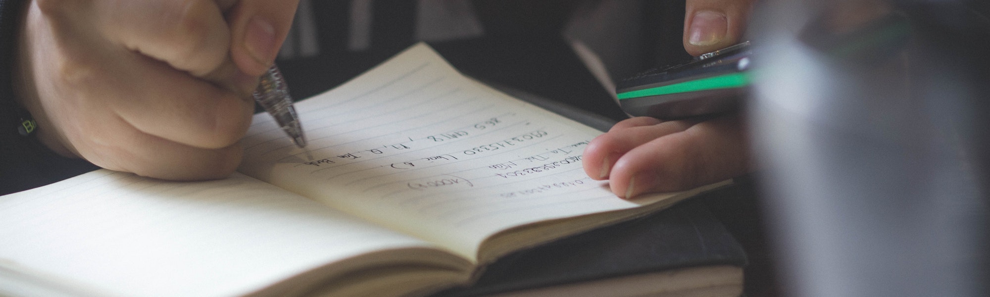 A person writing notes on a notebook