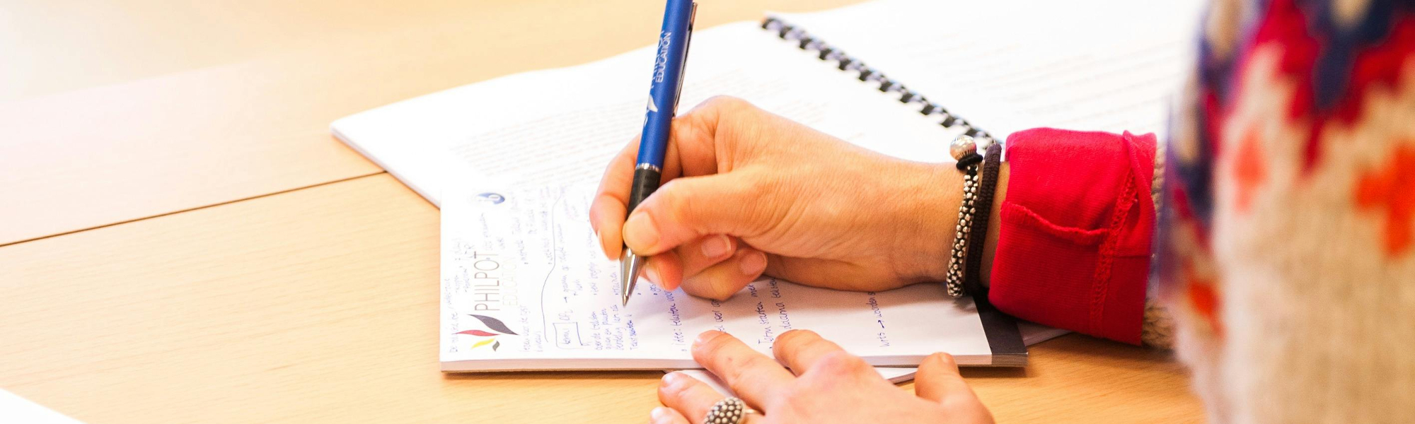 Woman Holding Blue Pen Writing on Paper