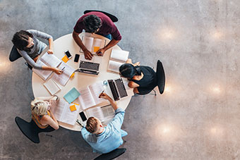 Group of students around a table discussing