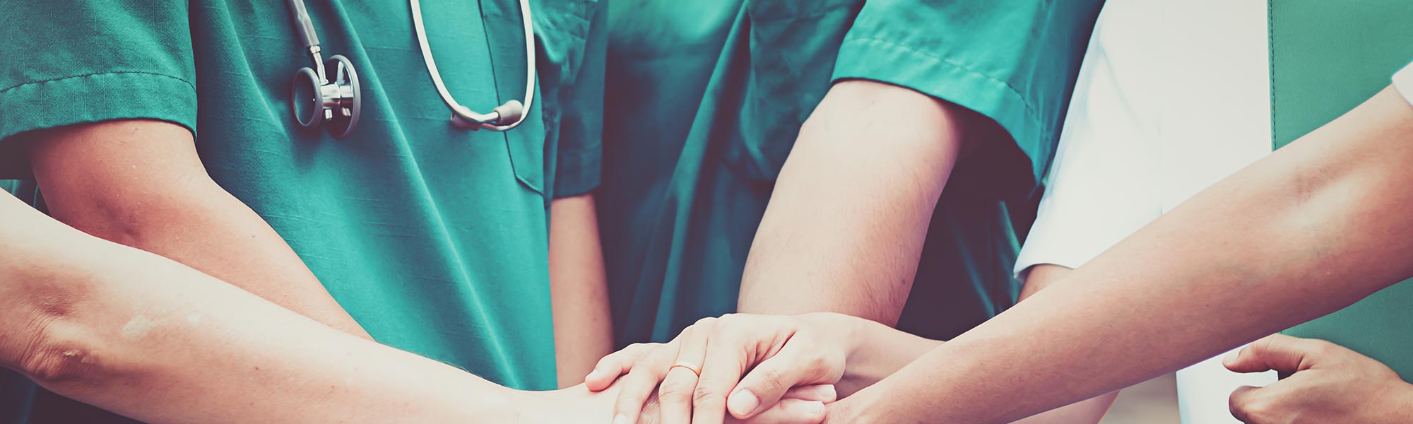 A group of doctors holding hands on top of each other