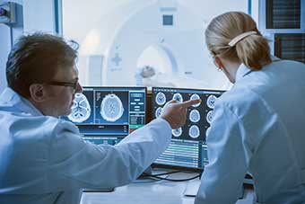 Two clinical radiologists examining an MRI