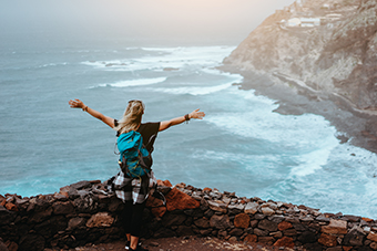 Girl facing the sea with arms wide open