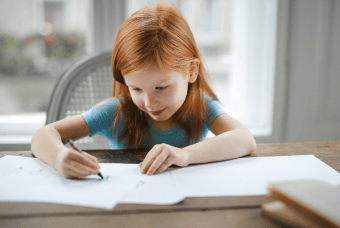 Young girl drawing on a large sheet of paper