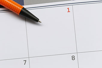 A pen resting on a paper calendar