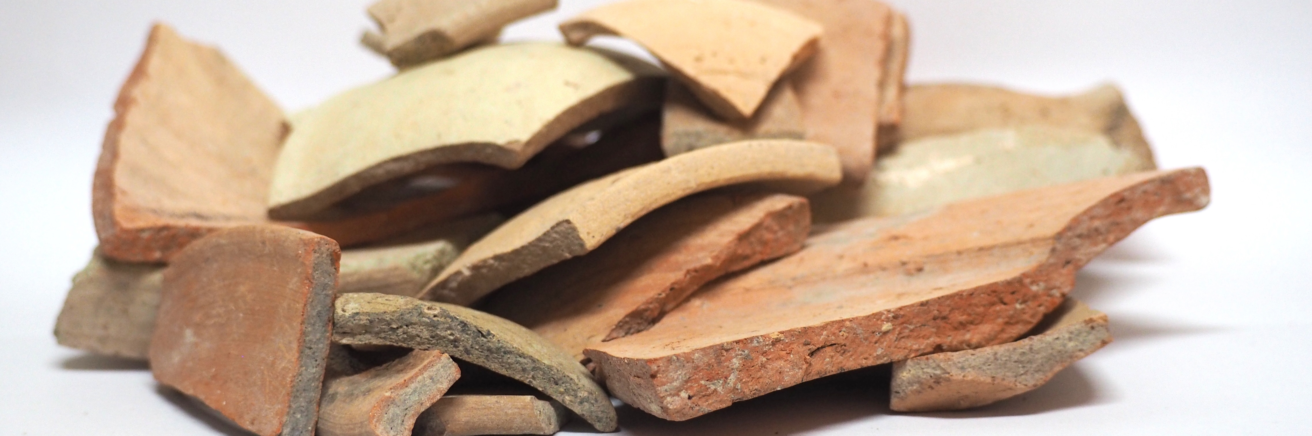 A group of roman pottery sherd on a white background