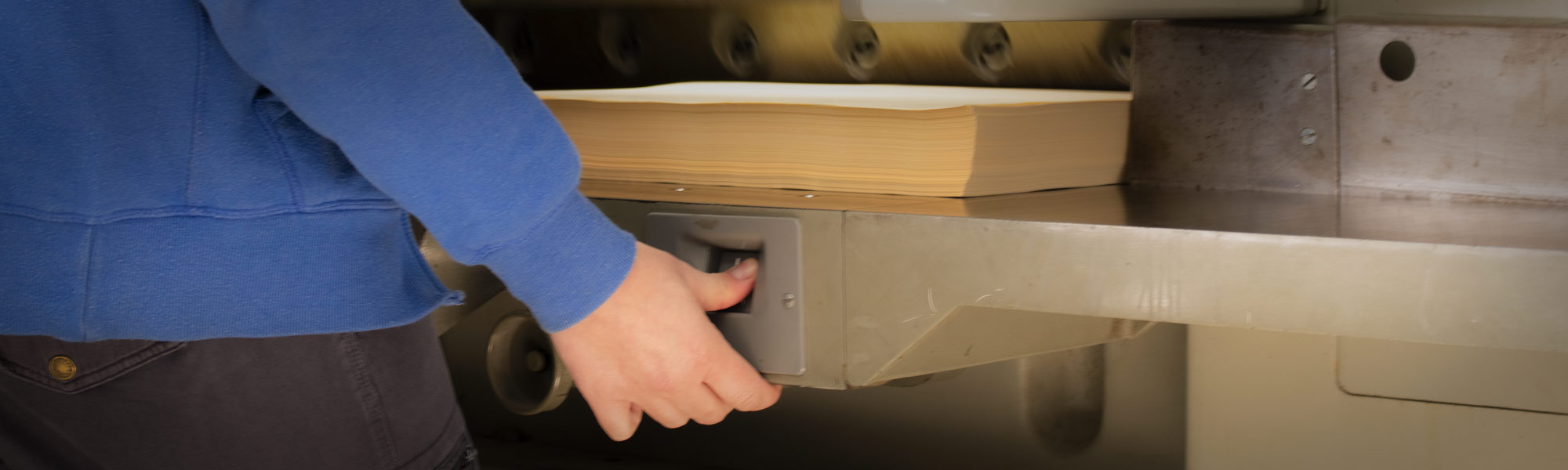 A person pressing a button to start a printing machine