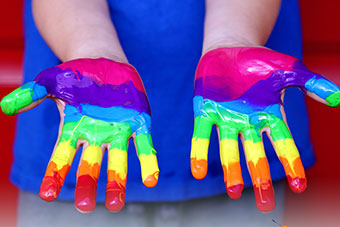 Two hands painted in various colours