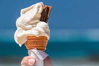 Hand holding a melting ice-cream in cone