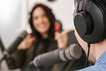 Two persons with headphones and microphone