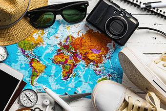 A pair of sunglasses, a camera, a world map, gym shoes