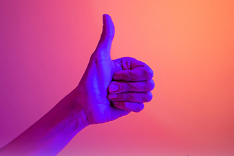 Thumbs up on a pinkish background