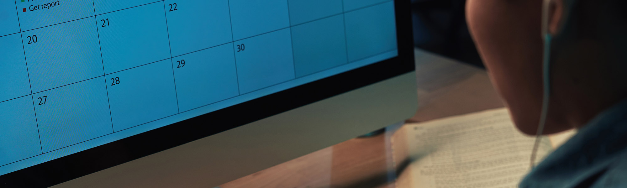 A computer screen with a calendar, a person a the side